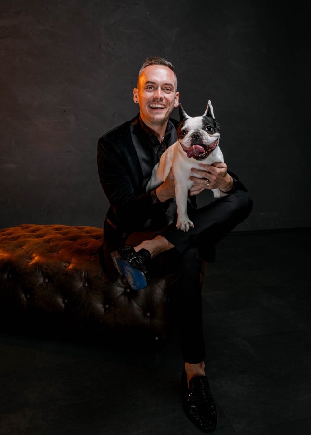 Tyler sitting with Leo on a leather ottoman