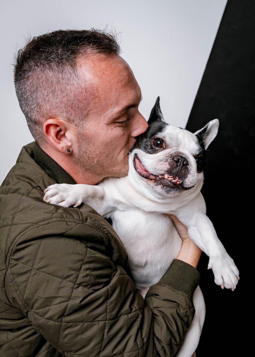 Tyler kissing Leo, his black-and-white French Bulldog