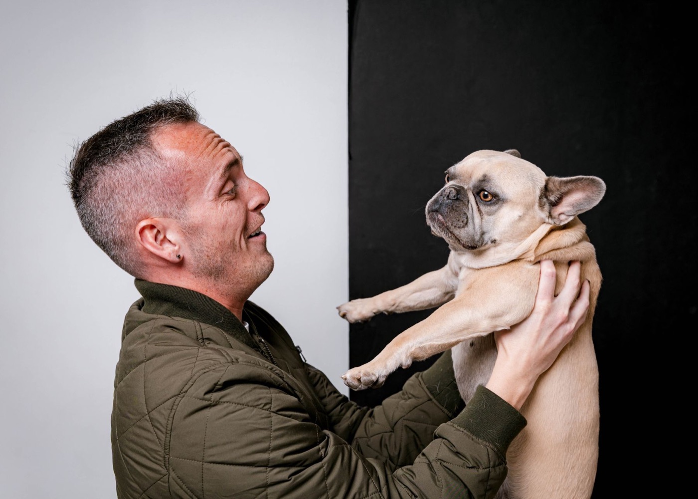 Tyler lifting Daisy, his fawn French Bulldog